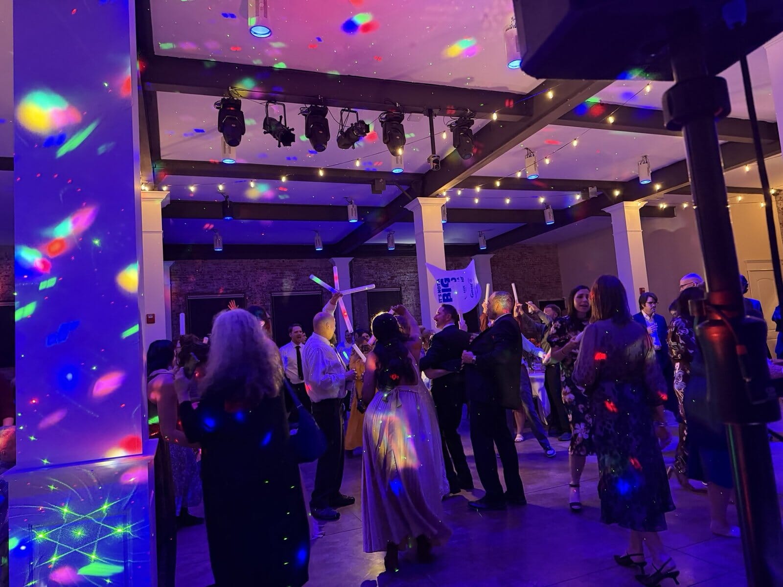 Guests dancing under colored dance-floor lighting at a City View at Sterling Square wedding reception in Evansville