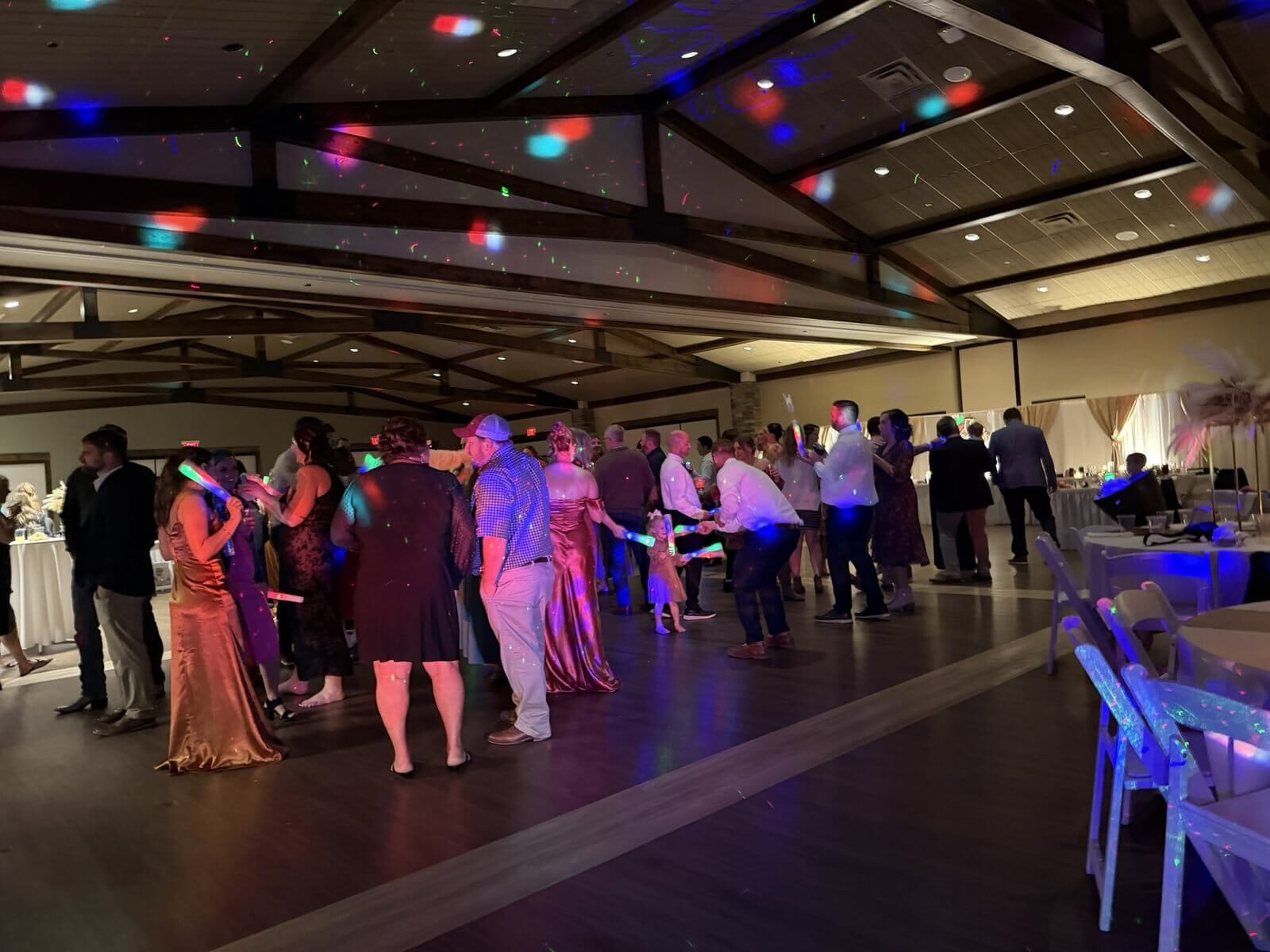 Guests dancing under colored lights with glow sticks at a Friedman Park wedding reception in Newburgh, Indiana