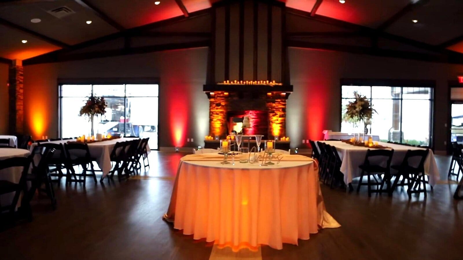 Head table and sweetheart table with amber uplighting at a Friedman Park Event Center wedding reception
