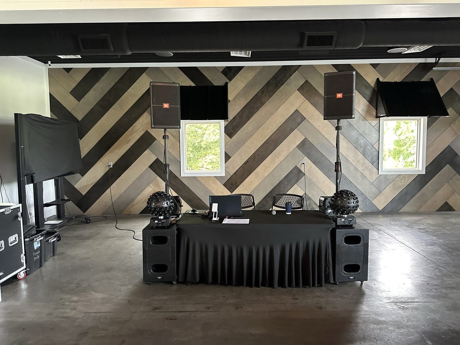 DJ booth set against the herringbone wood accent wall inside Event Barn A at Mahr Park Arboretum before a wedding